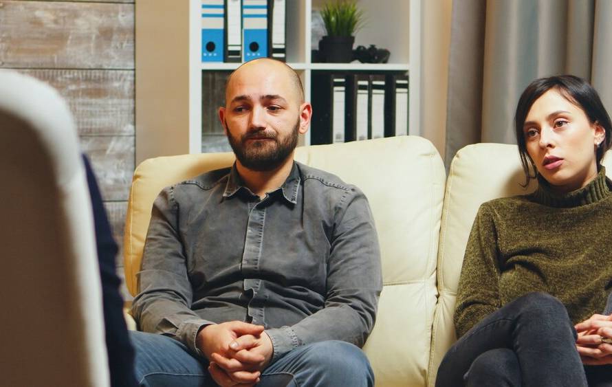 young-man-breathing-heavily-sitting-couch-with-his-wife-couple-therapy-talking-about-their-relationship_482257-25234.jpg